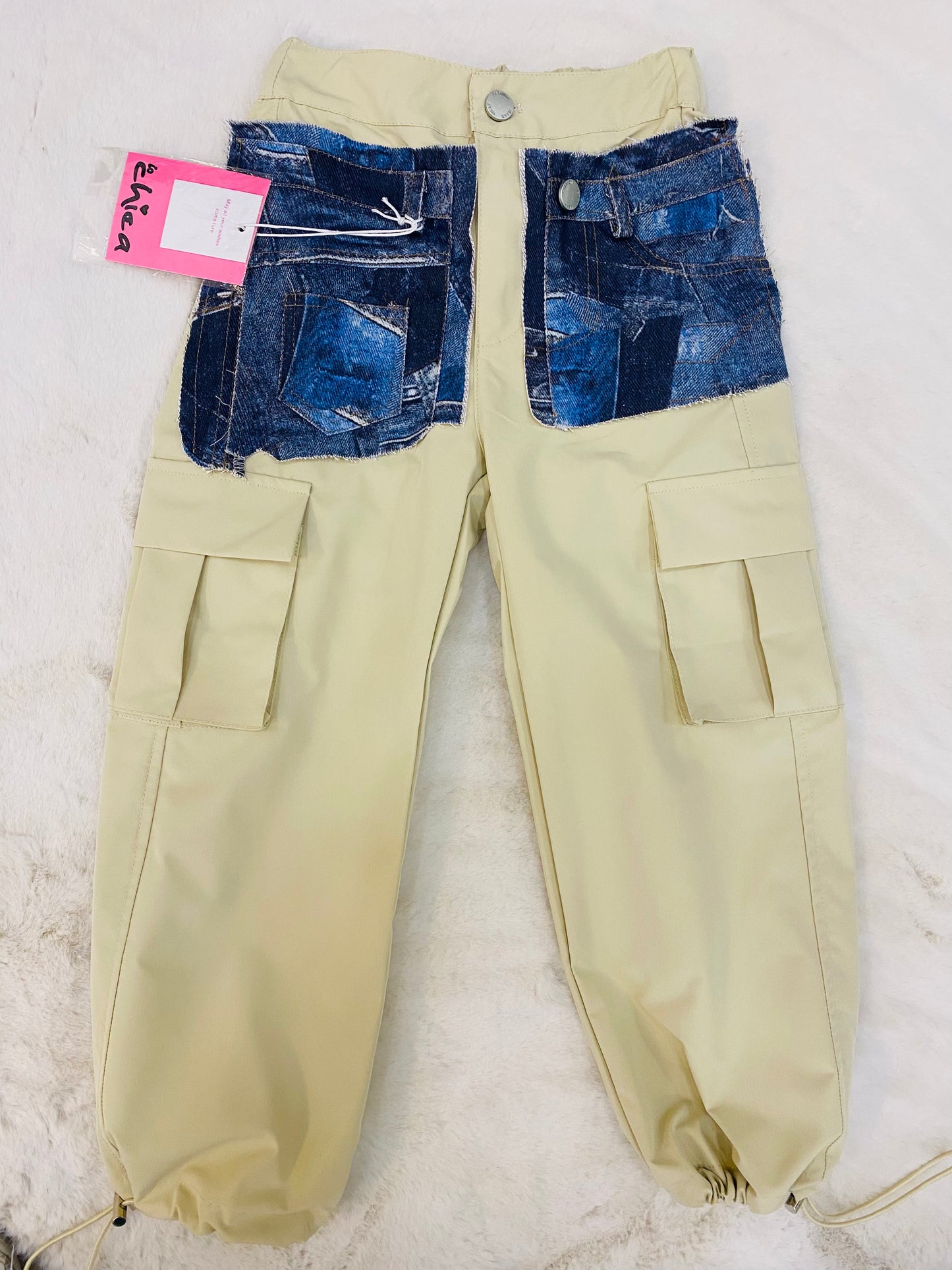 Pantalone cargo bambina beige con toppe in jeans, tasche laterali e fondo gamba elasticizzato.